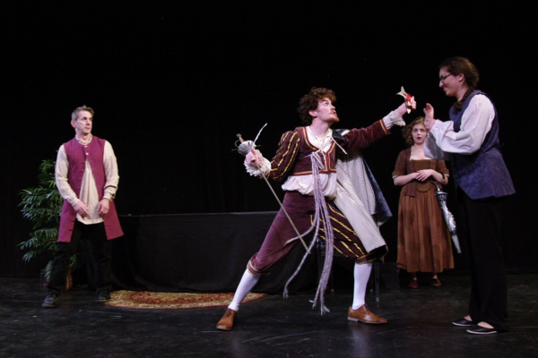 Four actors on a stage wearing Shakespearean era clothing