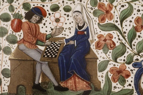 A man and a woman play chess while sitting on a bench and surrounded by flower wallpaper