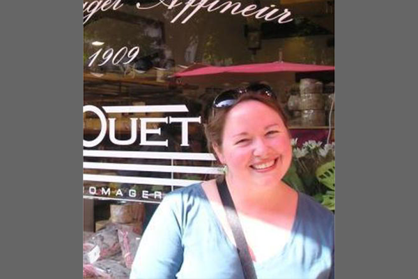 A woman in a blue shirt smiling at the camera