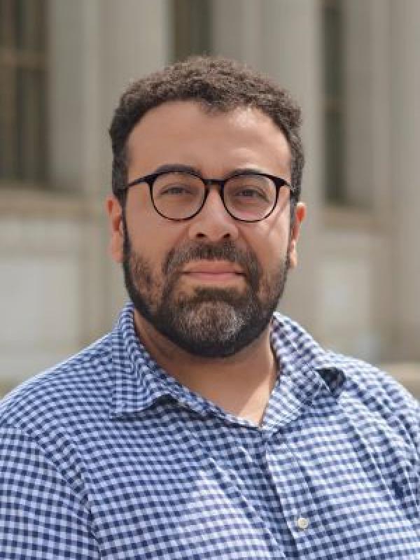 A man with round tortise shell glasses and a short beard